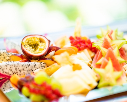 Obst Ein Obstteller mit Sternenfrucht. Melone, Beeren und Weintrauben.